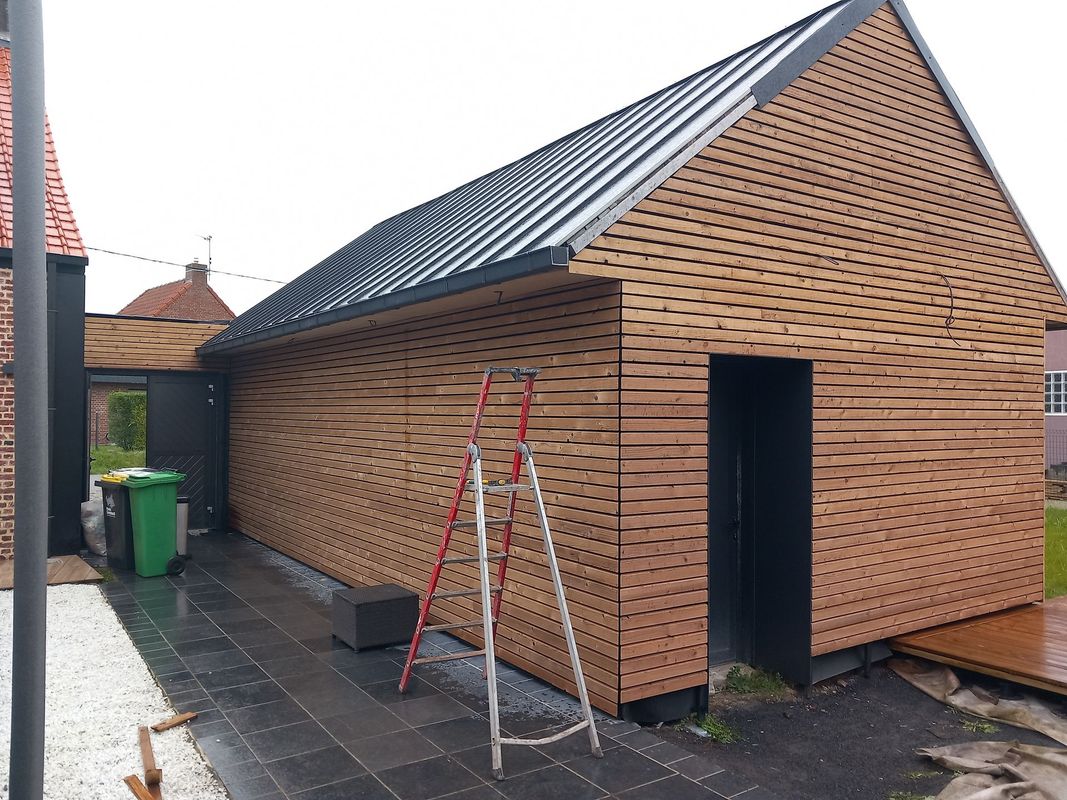 Une extension de maison avec bardage bois