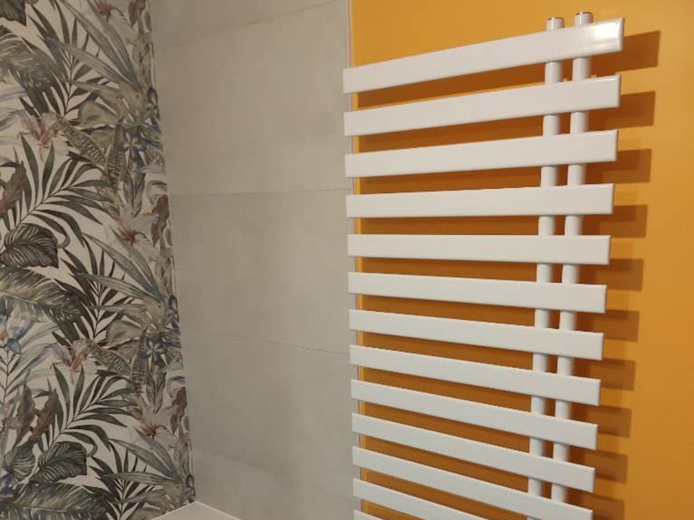 Radiateur sur un mur à côté d'un carrelage floral