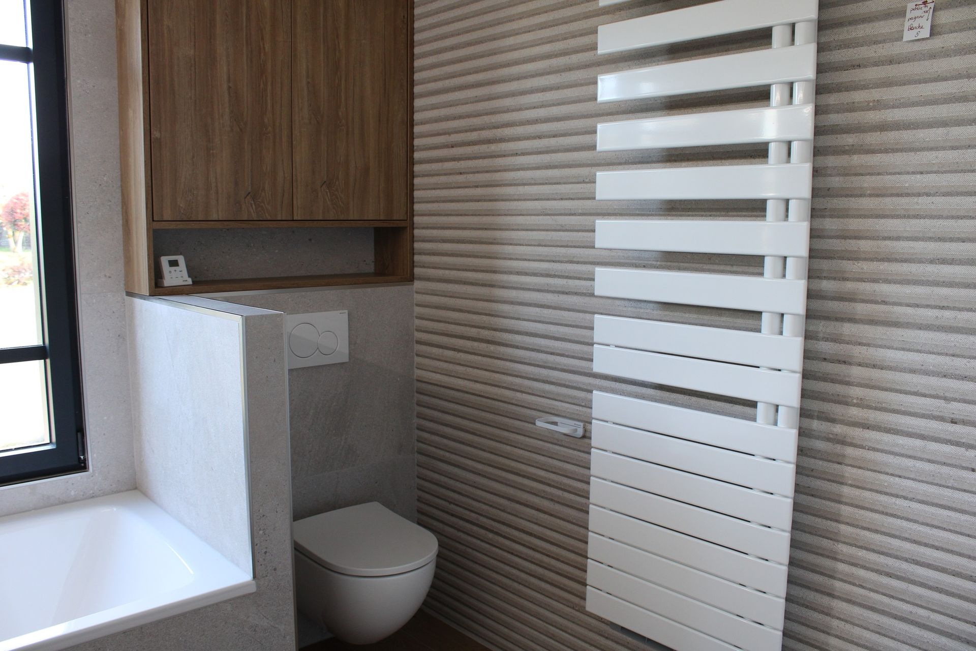 Salle de bains avec armoires en bois, sèche-serviettes blanc et toilettes