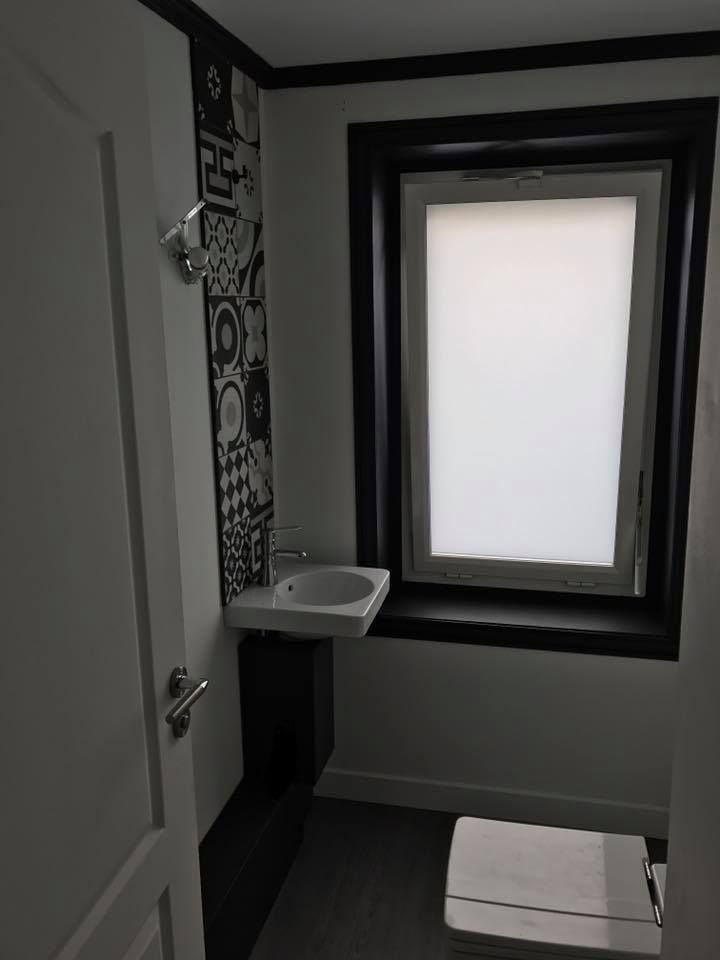 Petite salle de bains avec lavabo, toilettes et fenêtre