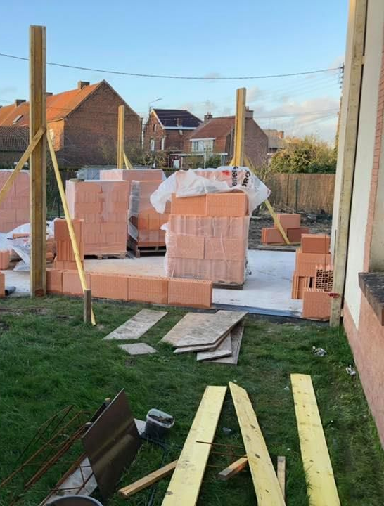 Chantier de construction d'extension avec briques rouges empilées