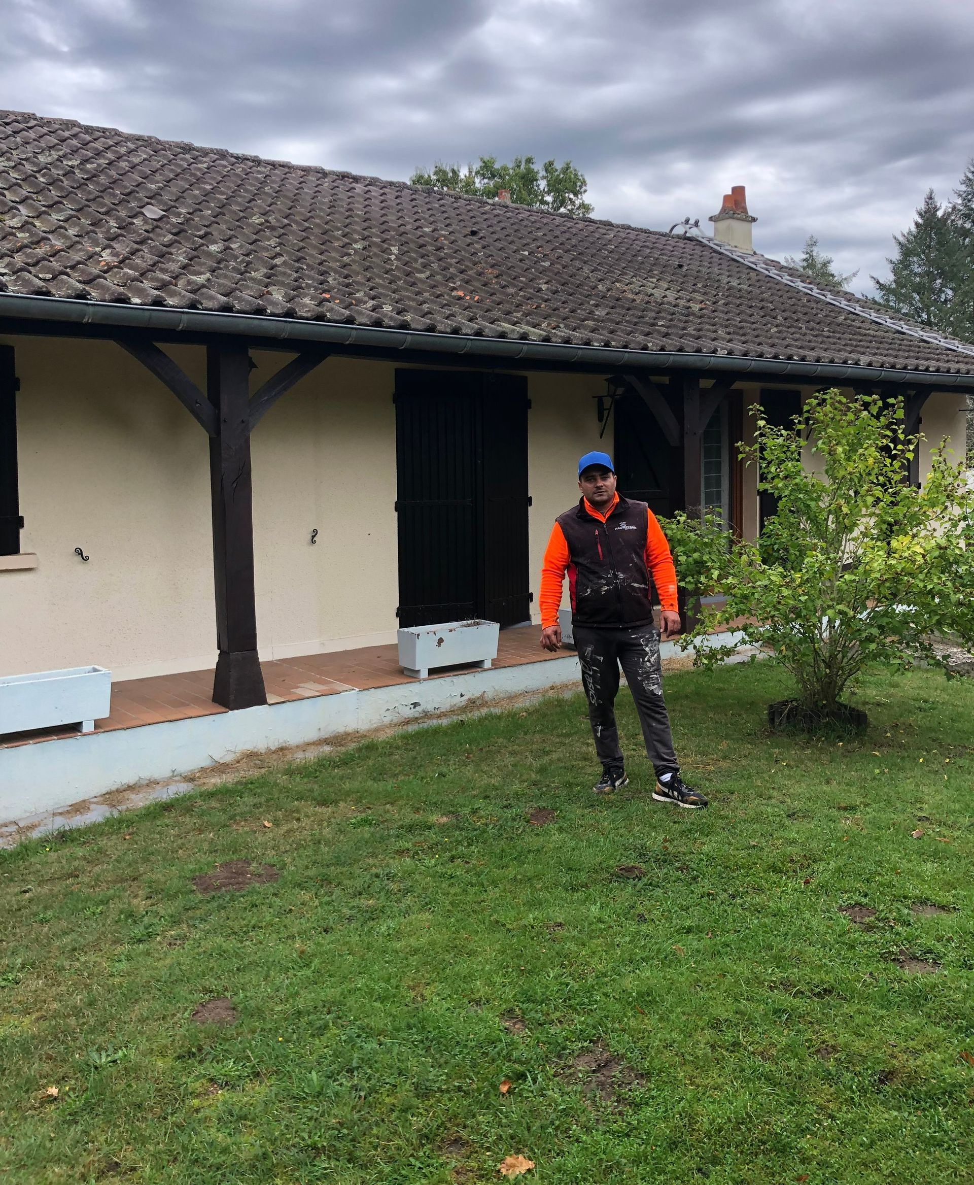 Un artisan devant une terrasse et un toit sale