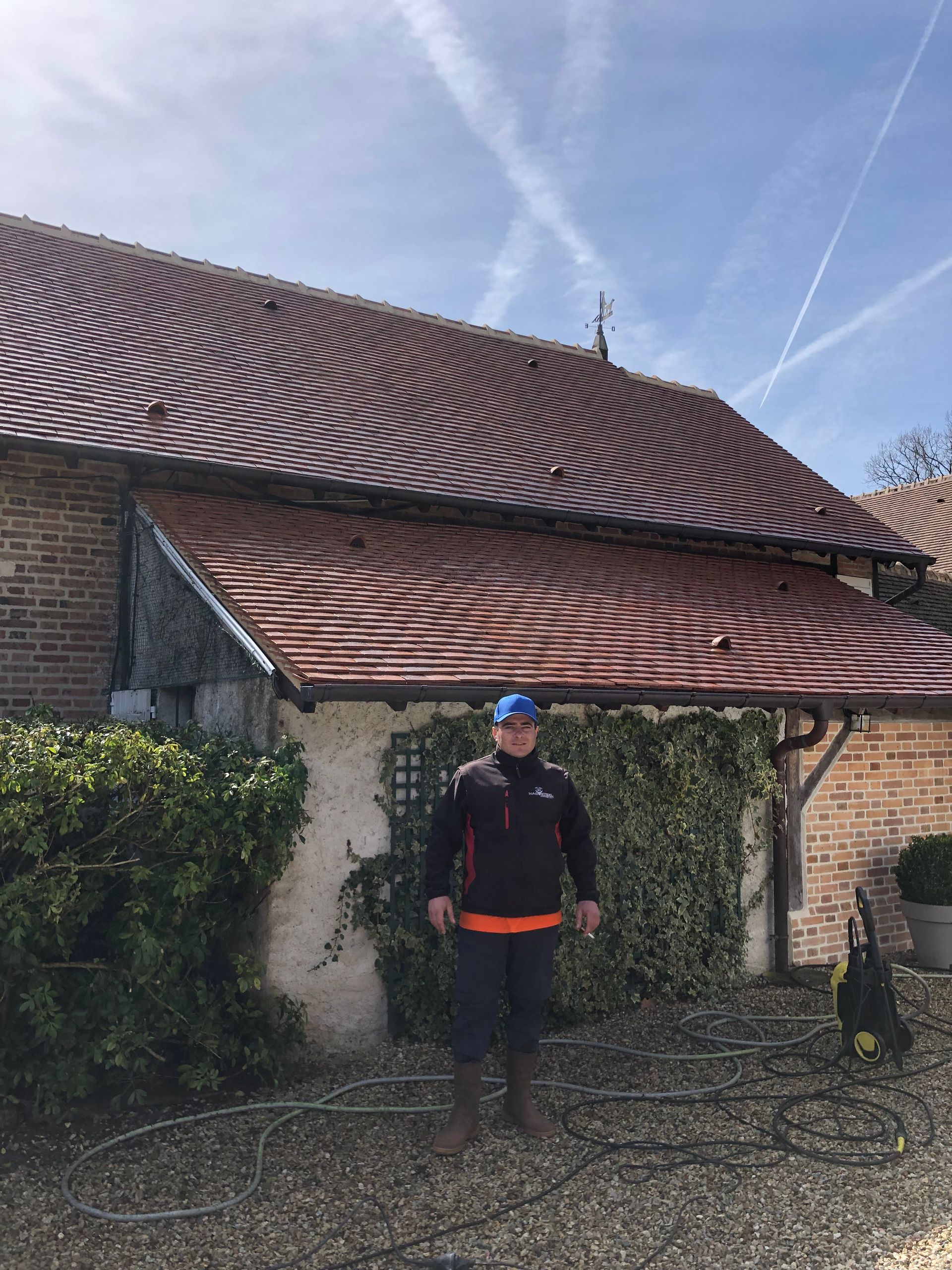 Un artisan devant un toit avec une girouette