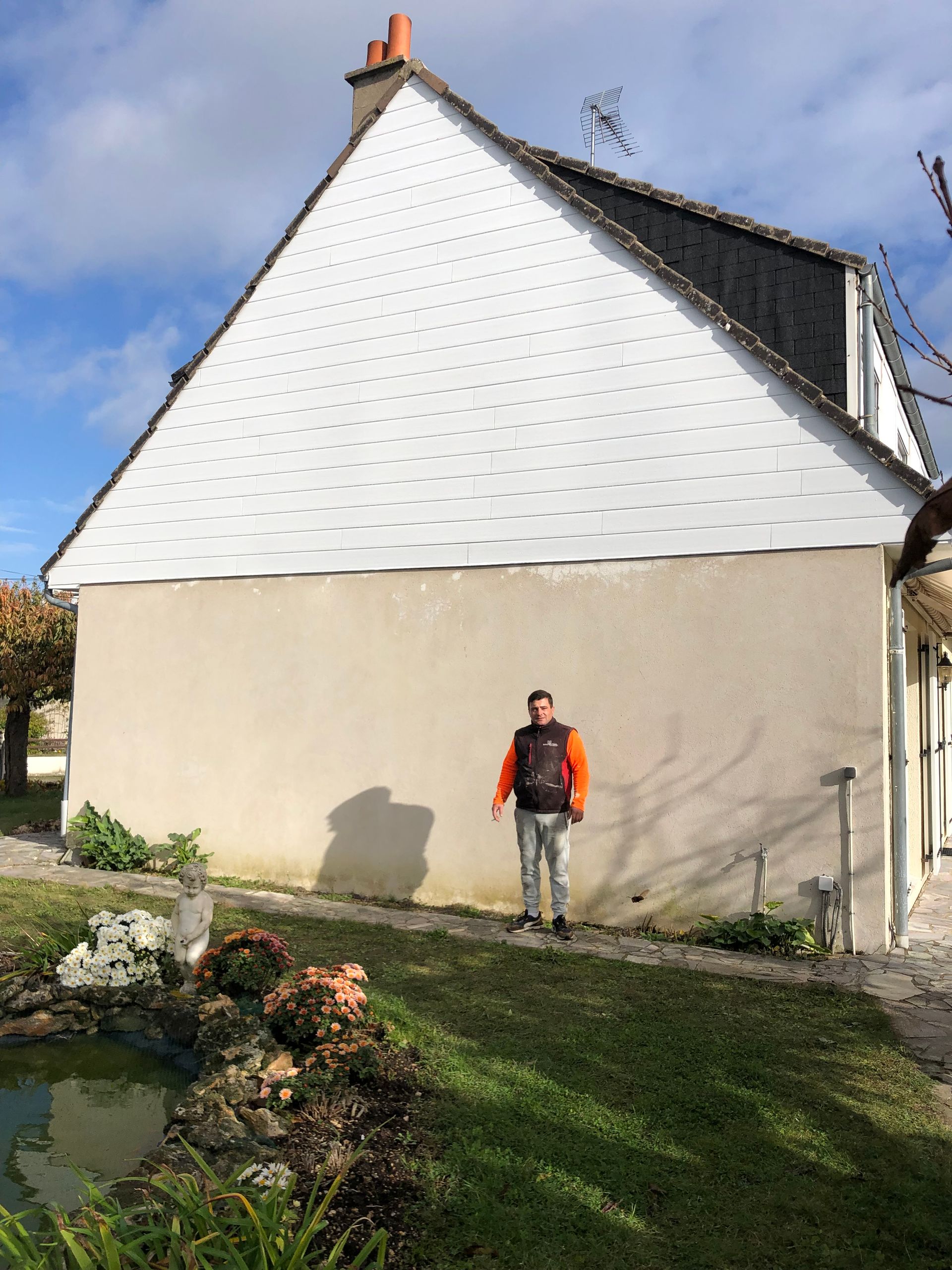 Un artisan devant un mur extérieur déjà nettoyé
