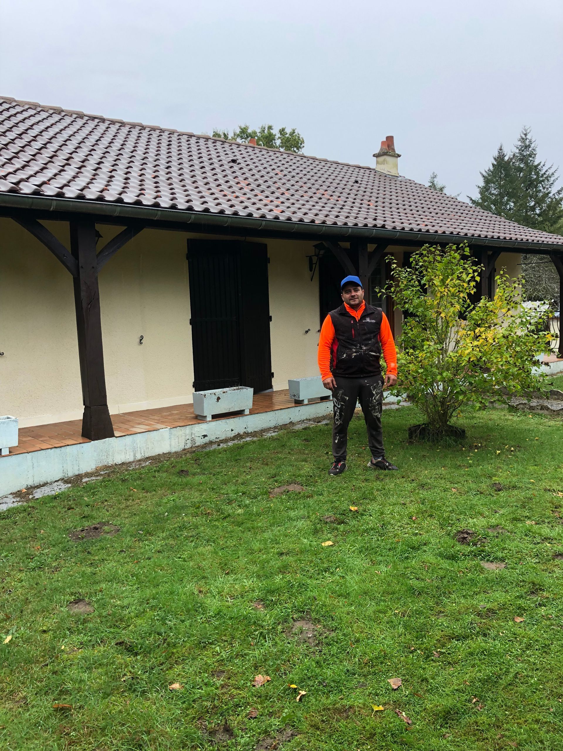 Un artisan devant une terrasse et un toit propre