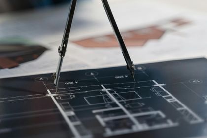 Compas de dessinateur au-dessus d'un plan d'architecte sur une table