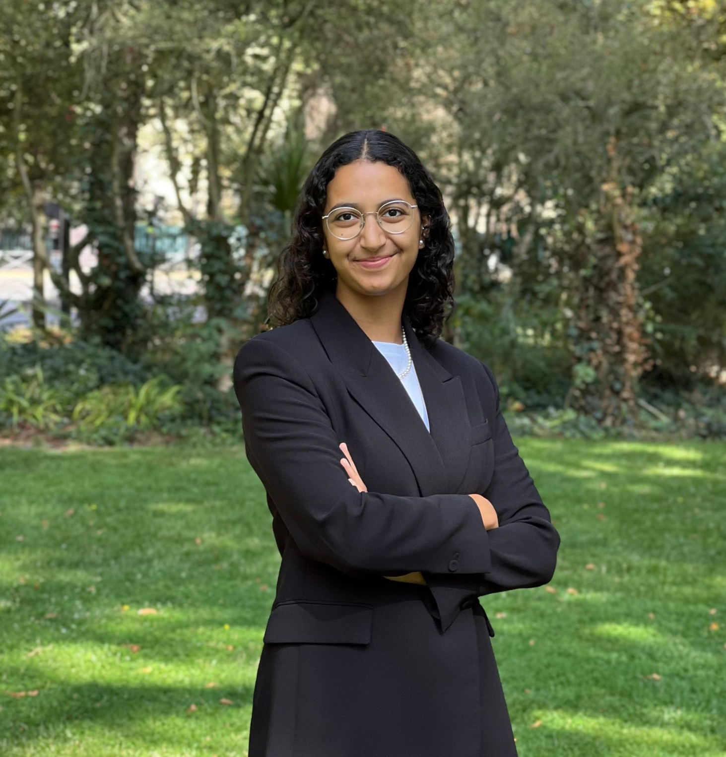 Ein Mann in Anzug und Krawatte steht vor einer großen weißen Skulptur.