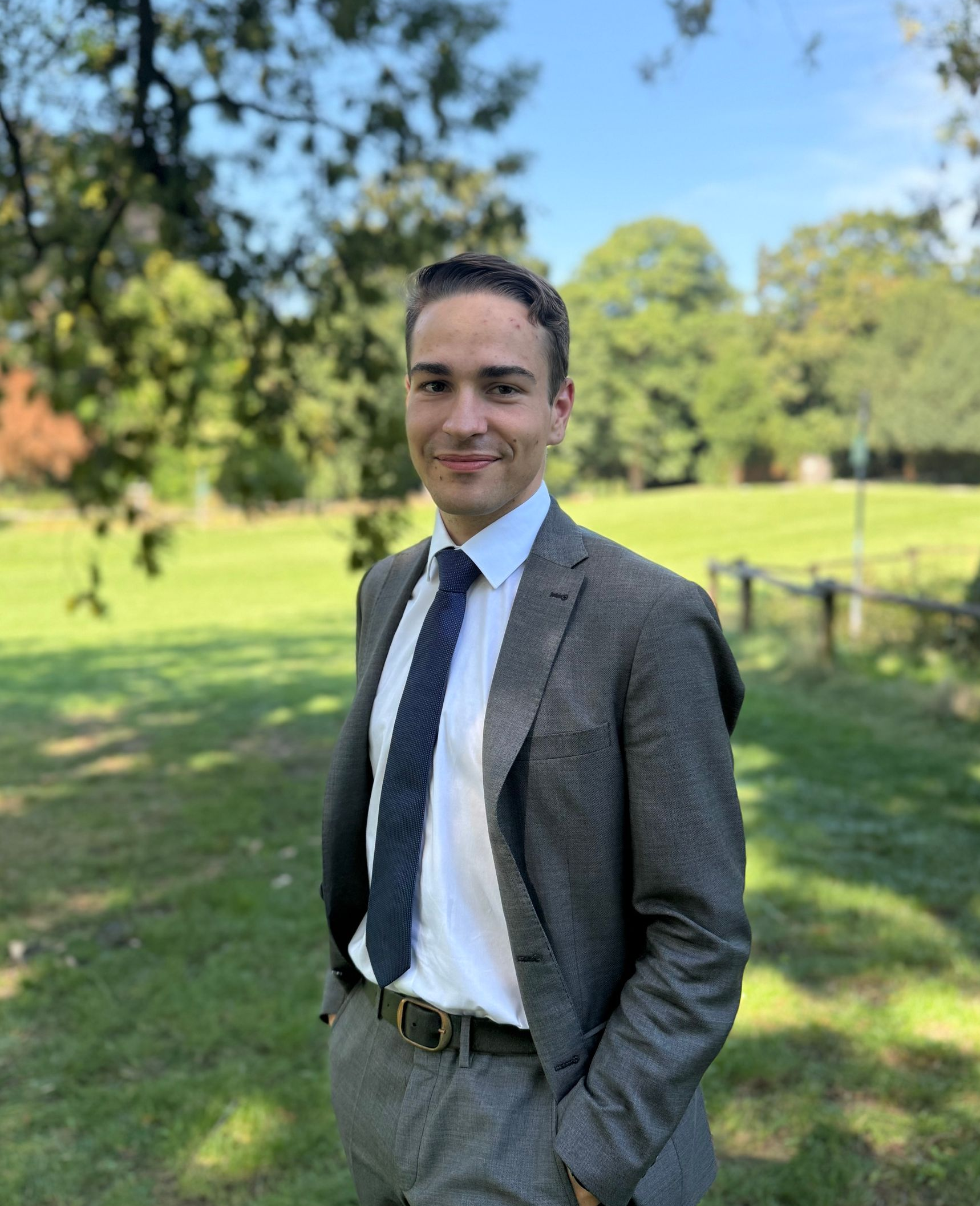 Eine Frau in einer blauen Jacke und einem weißen Hemd lächelt in die Kamera.