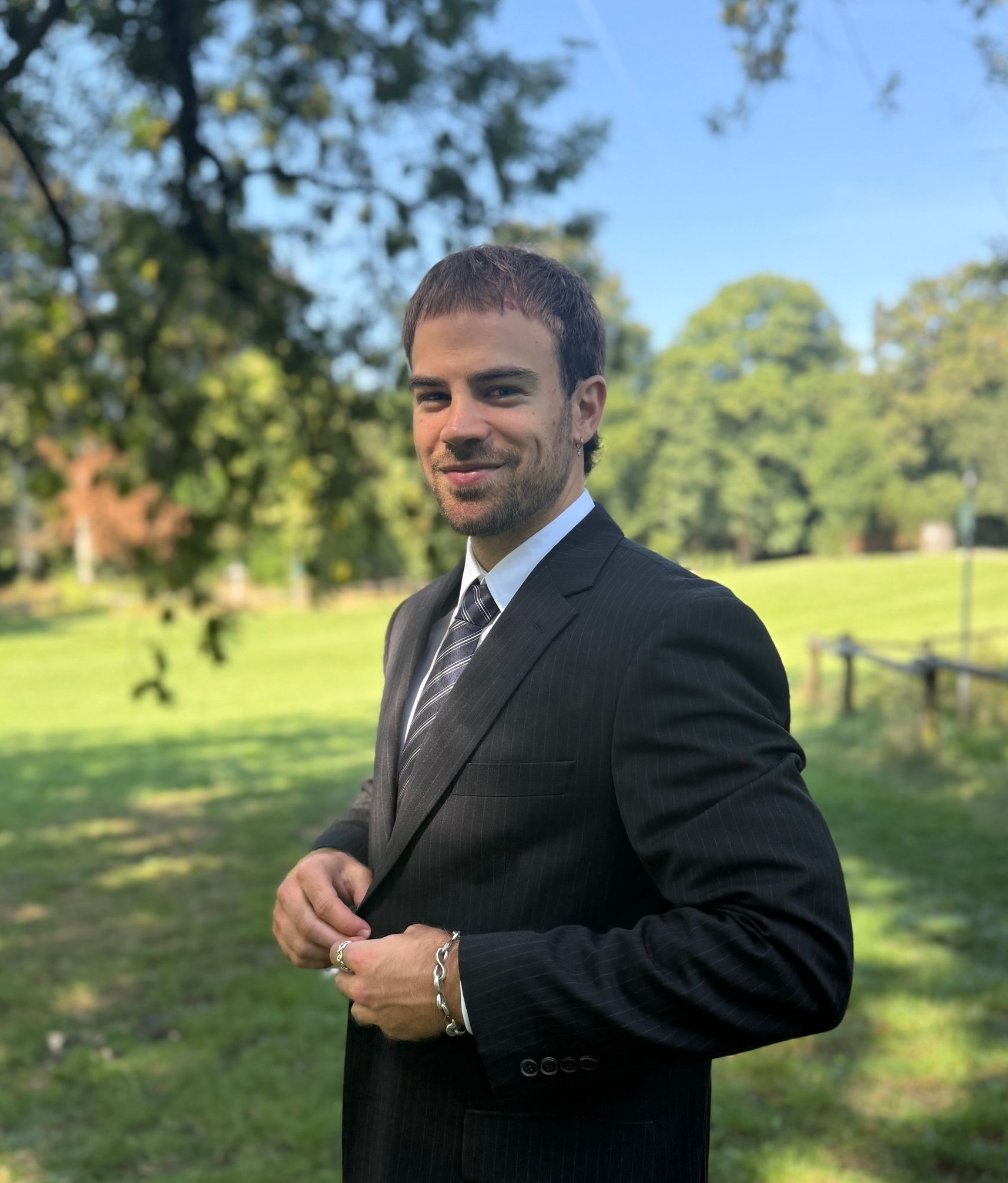 Eine Frau im Anzug steht vor einer großen weißen Statue.