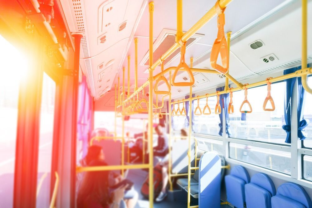 El interior de un autobús con muchas manijas colgando del techo.