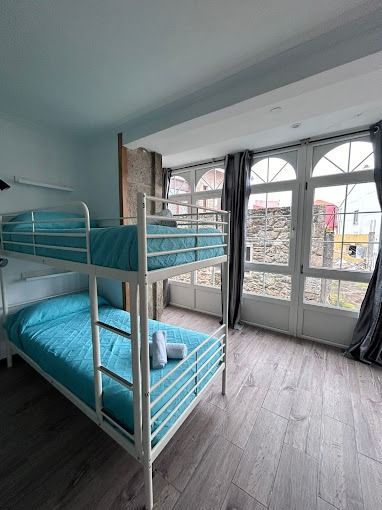 Hay dos literas en la habitación con muchas ventanas.