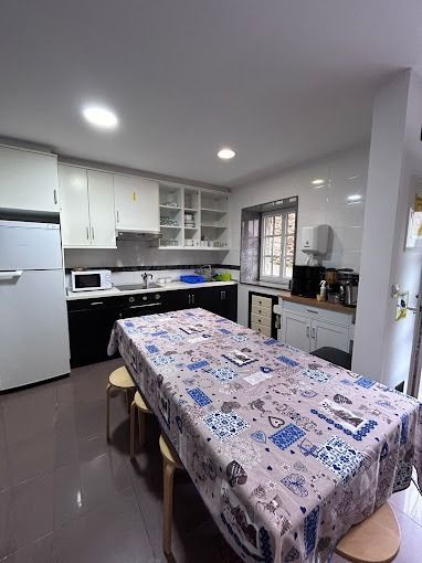 Una cocina con una mesa y taburetes y un frigorífico.