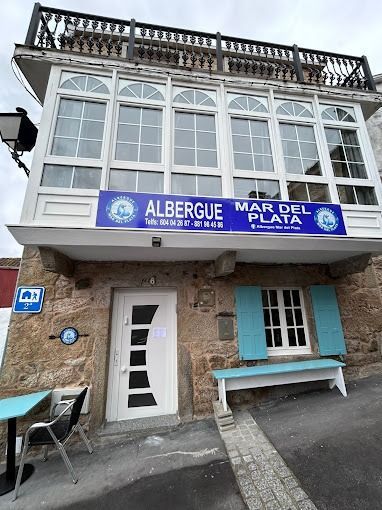 Un gran edificio con un cartel azul que dice albergue mar del plata