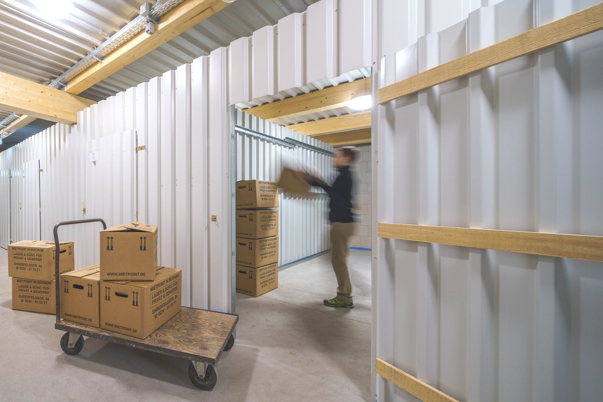 Ein Mann sitzt auf dem Boden und verklebt einen Karton