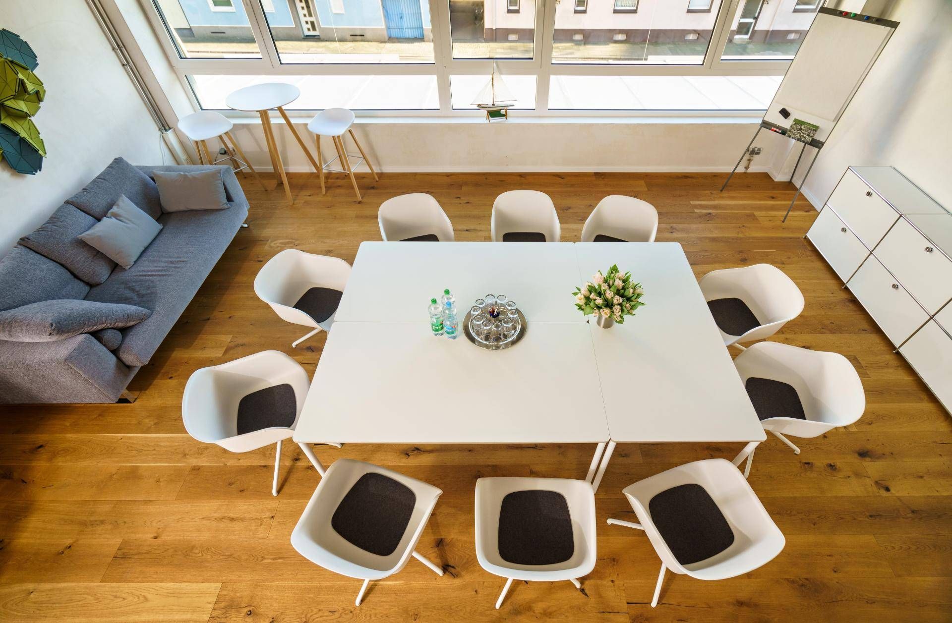 Eine Luftaufnahme eines Konferenzraums mit einem weißen Tisch und Stühlen