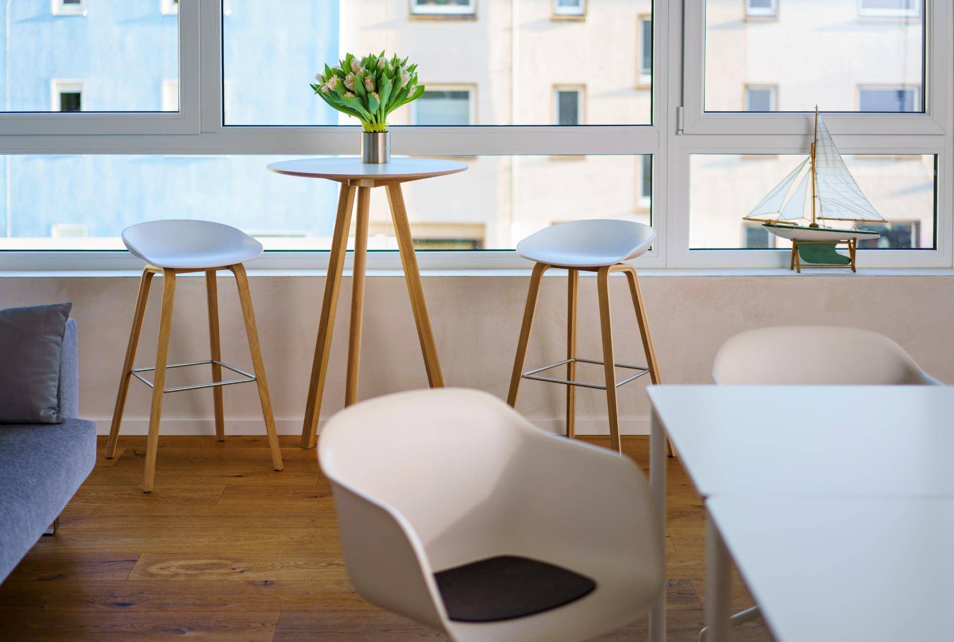 Heller Seminarraum mit einem Tisch und Stühlen vor einem Fenster