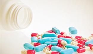 Se vierte un frasco de pastillas en una pila de pastillas.