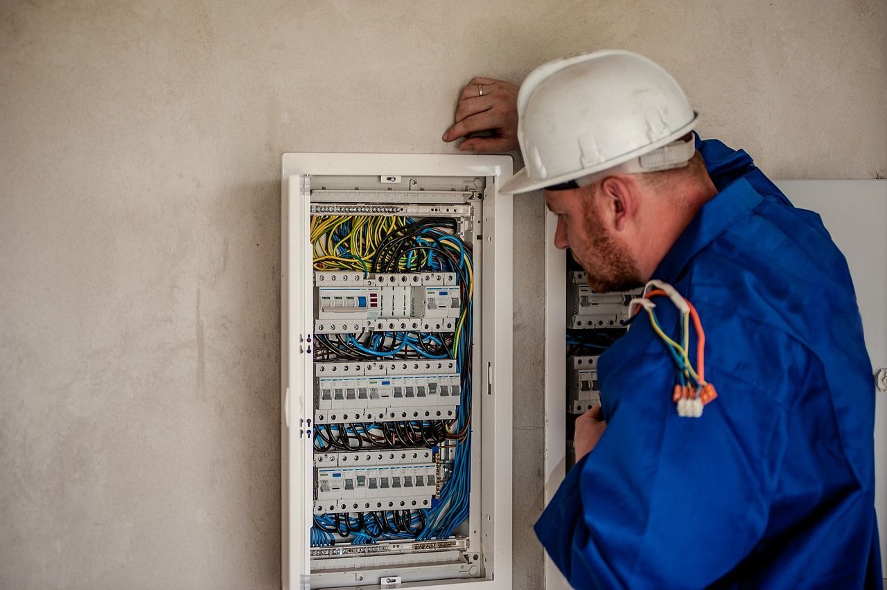 Un electricista está trabajando en una caja eléctrica.