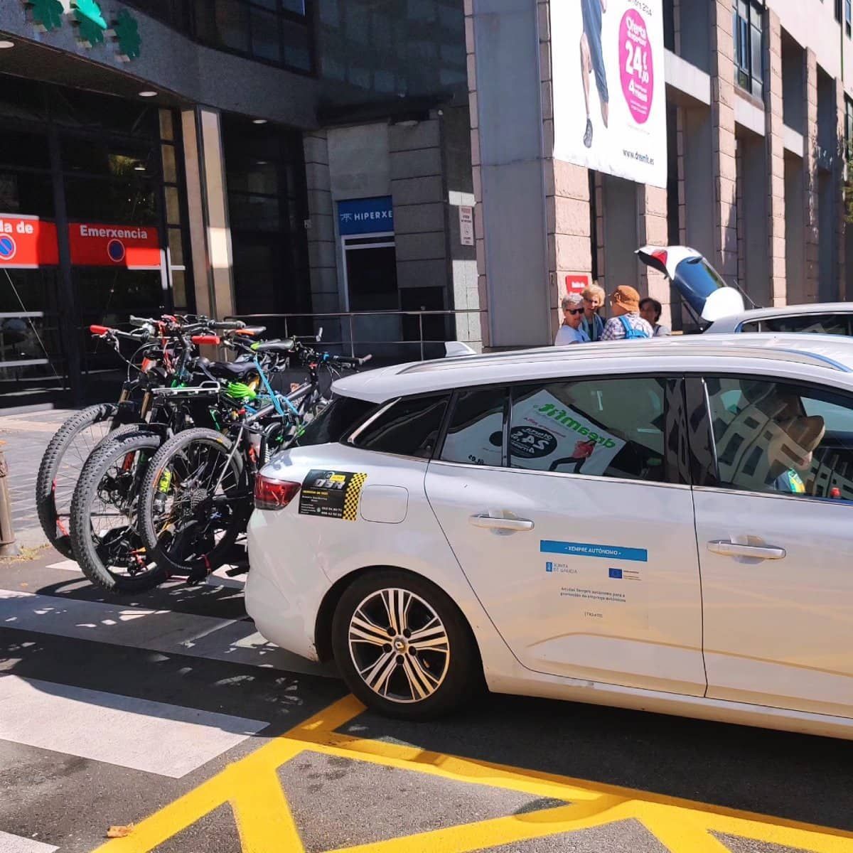 Un automóvil blanco con bicicletas atadas.