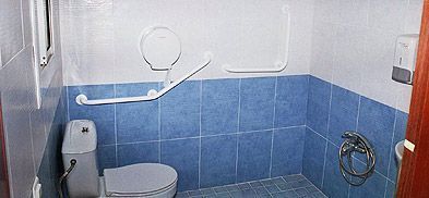 Un baño con azulejos azules, un inodoro y un grifo.