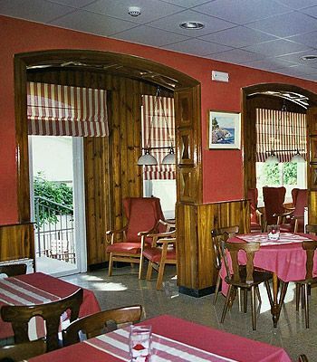 Un restaurante con mesas y sillas con un mantel rojo.