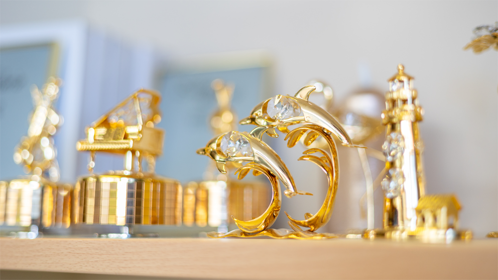 Ein Regal mit vielen Goldverzierungen darauf.