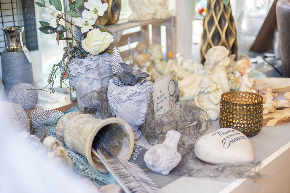 Ein Tisch mit verschiedenen Dekorationen, darunter einer Blumenvase und einer Feder.