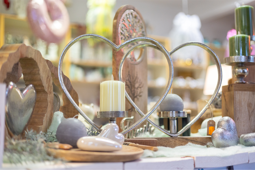 Ein Tisch mit einem herzförmigen Kerzenständer und Kerzen darauf.