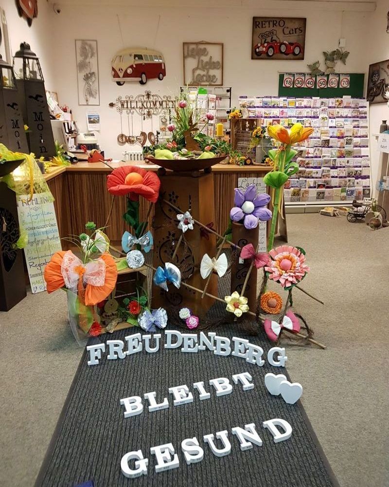 A store with flowers and a sign that says freudenberg bleibt gesund