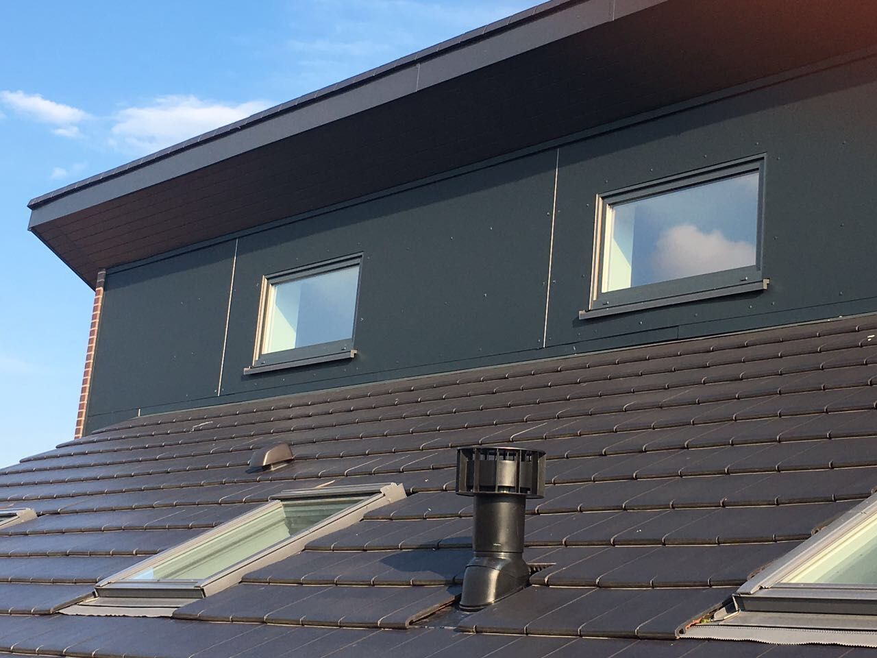 Ein Dach mit zwei Oberlichtern und einem Schornstein darauf