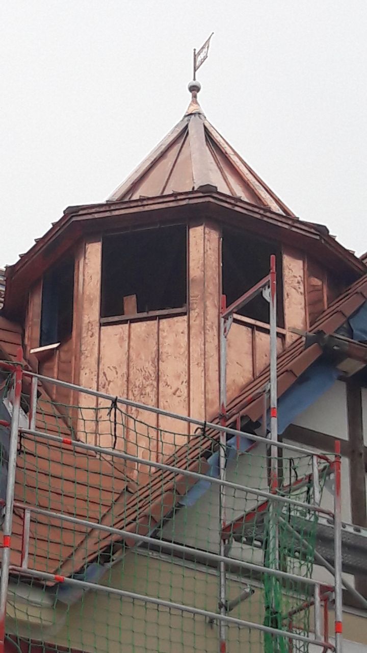 Ein Kupferdach mit einer Wetterfahne darauf