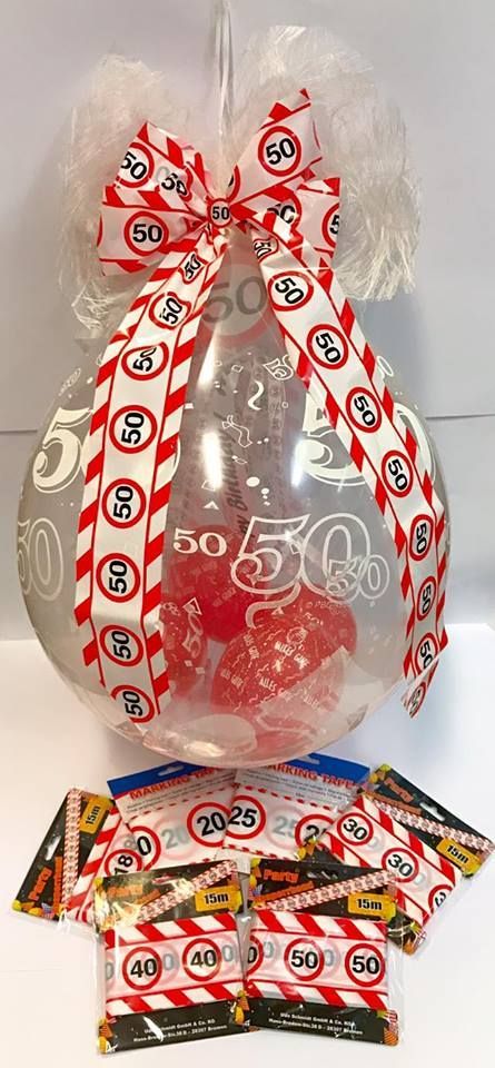 Ein durchsichtiger Ballon, gefüllt mit Süßigkeiten und einer rot-weißen Schleife.