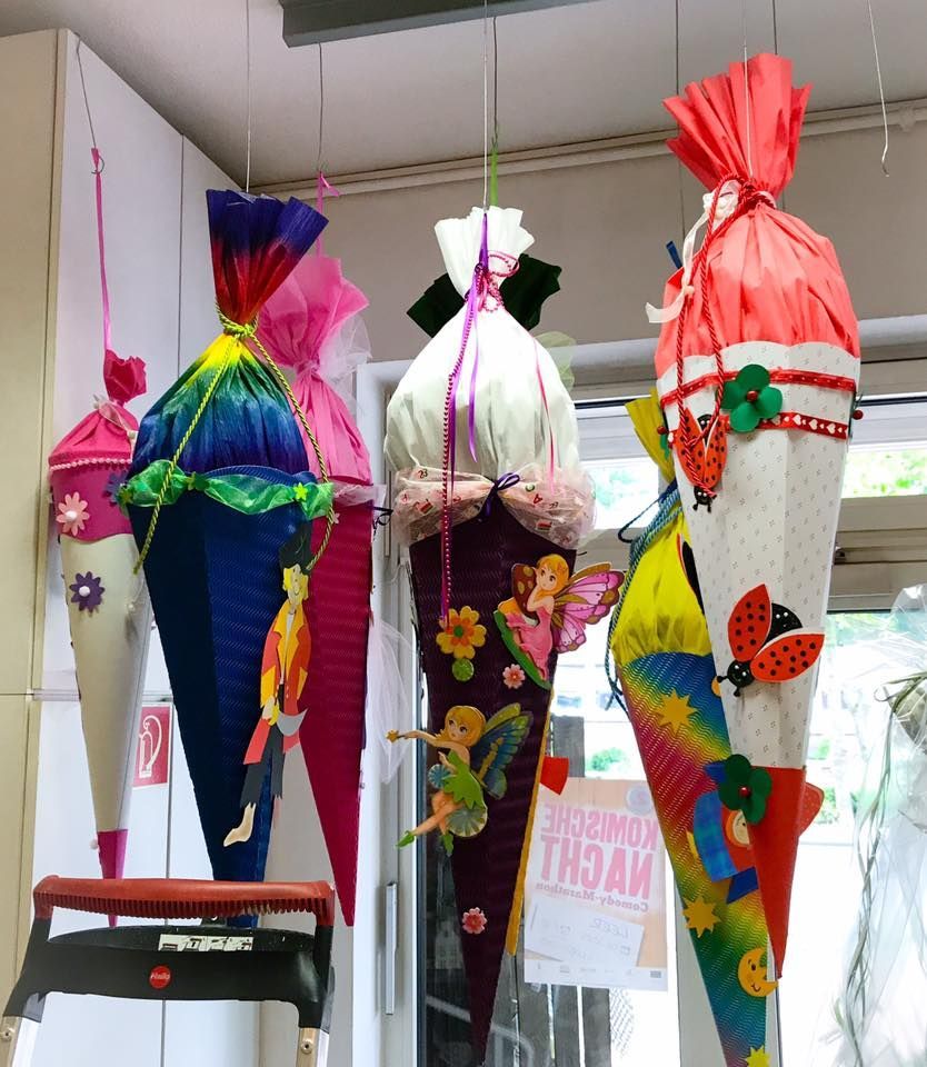 Mehrere bunte Kegel hängen von der Decke mit einem Schild mit der Aufschrift