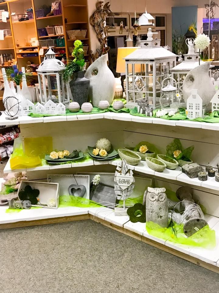 Eine Ausstellung von Laternen und Vasen auf Regalen in einem Geschäft.