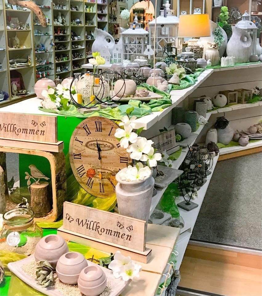 Eine Uhr auf einem Tisch mit Blumen und einem Schild mit der Aufschrift „Willkommen“