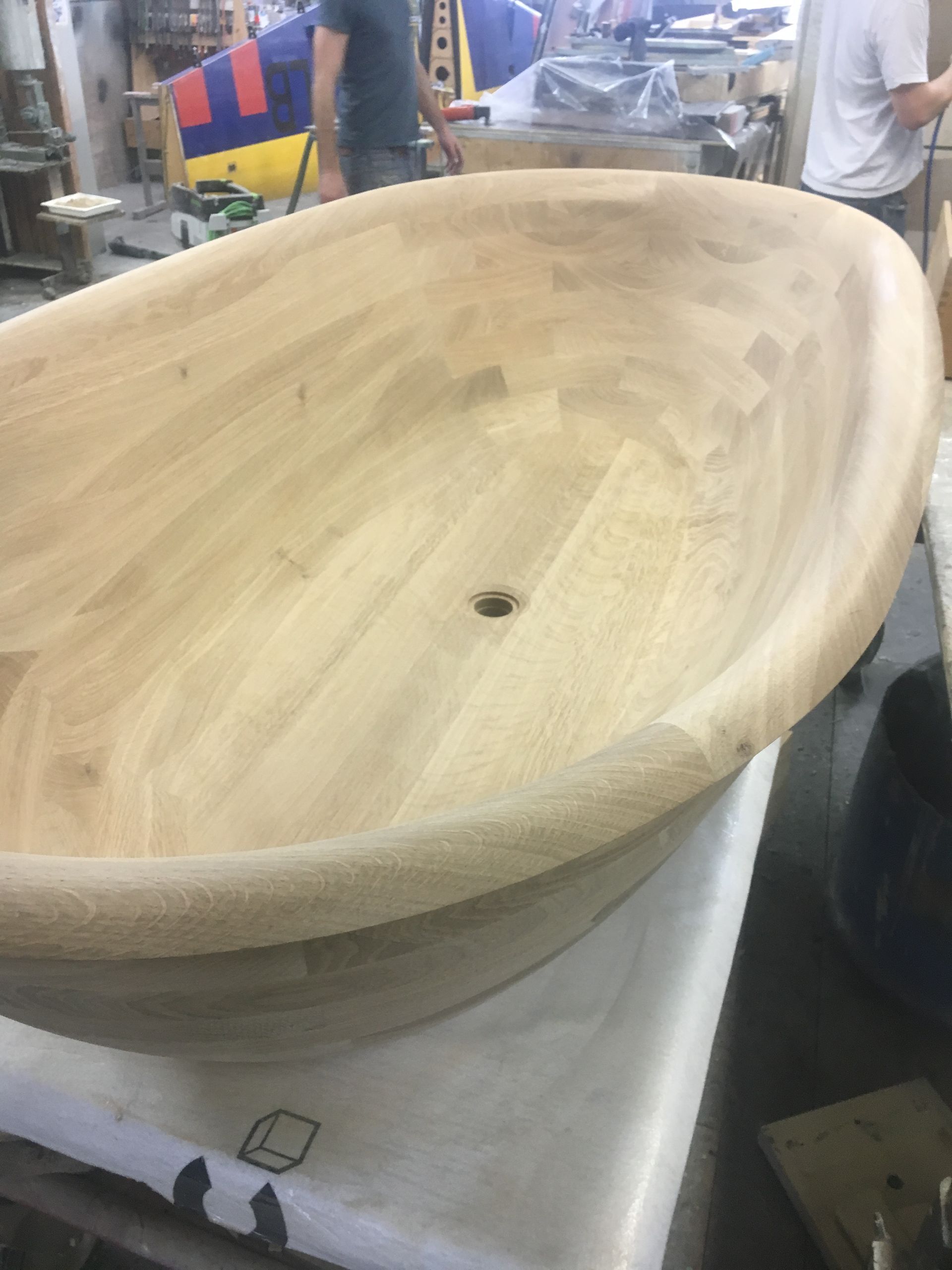 A large wooden bowl is sitting on top of a table.