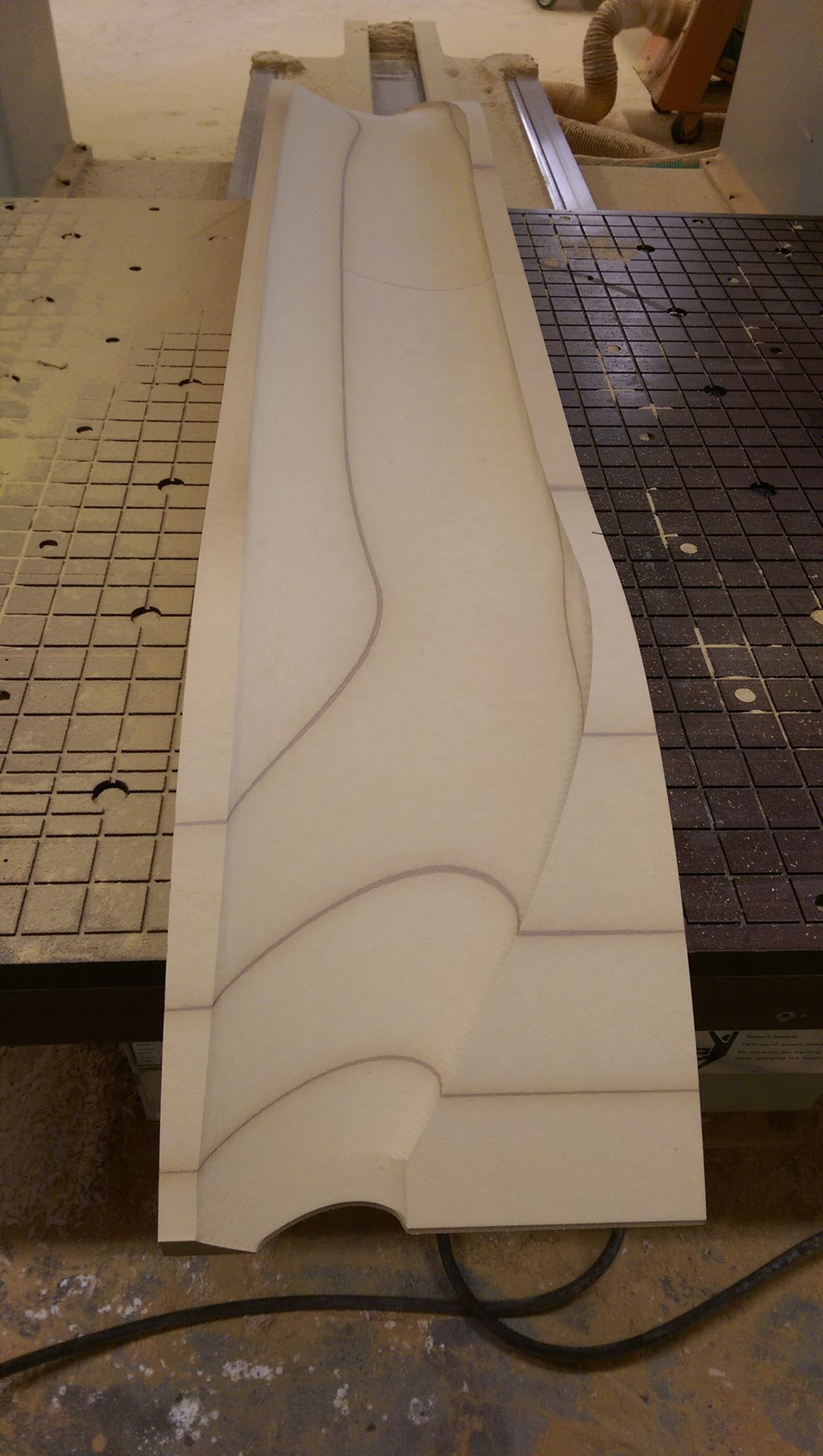 A piece of wood is being cut on a machine.