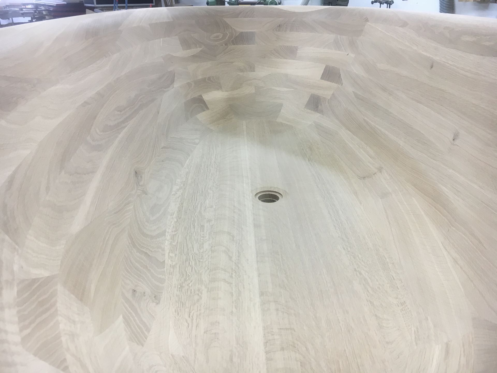 A large wooden bowl with a hole in the middle is sitting on a table.