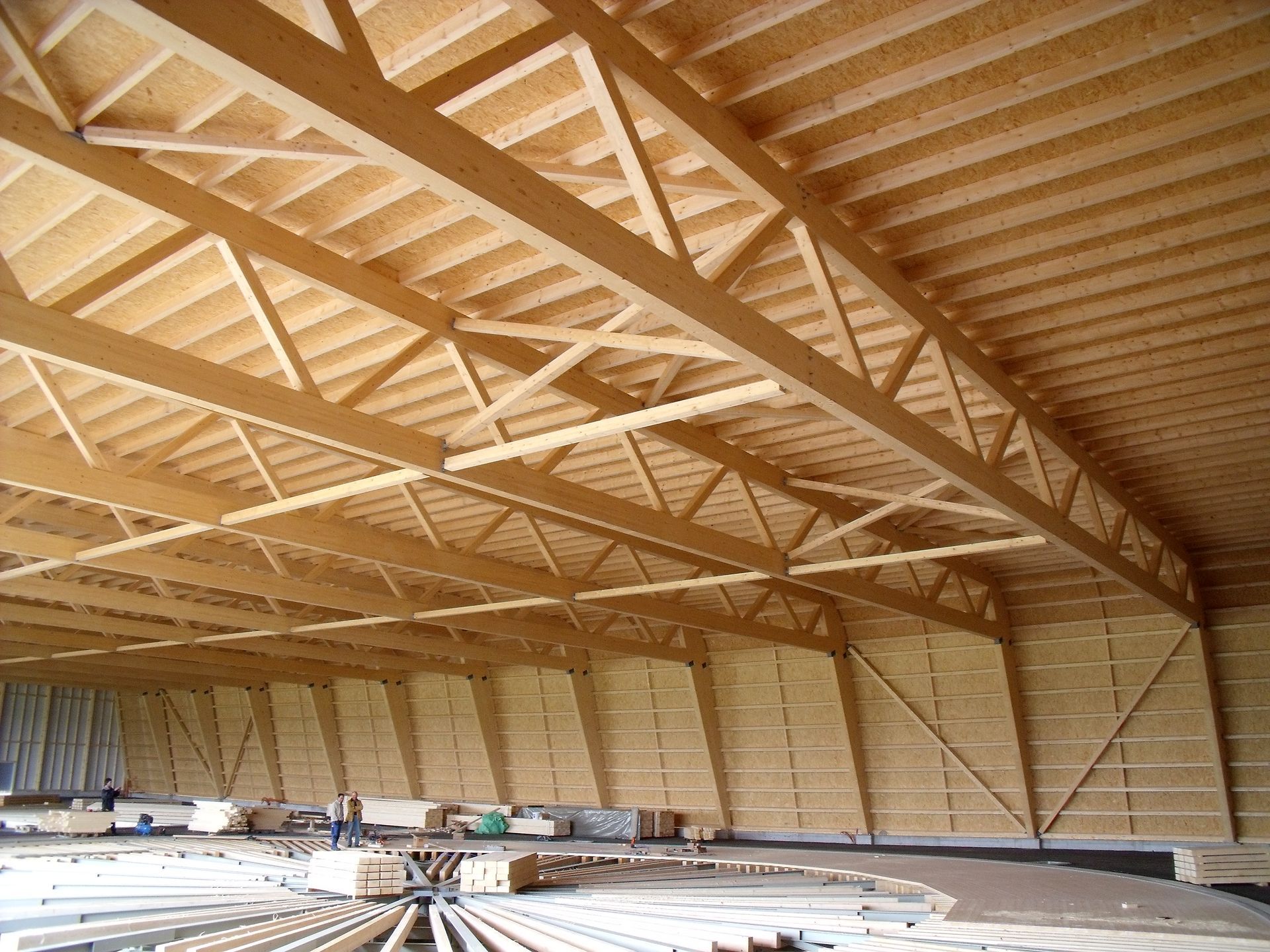 The inside of a large building with a wooden roof