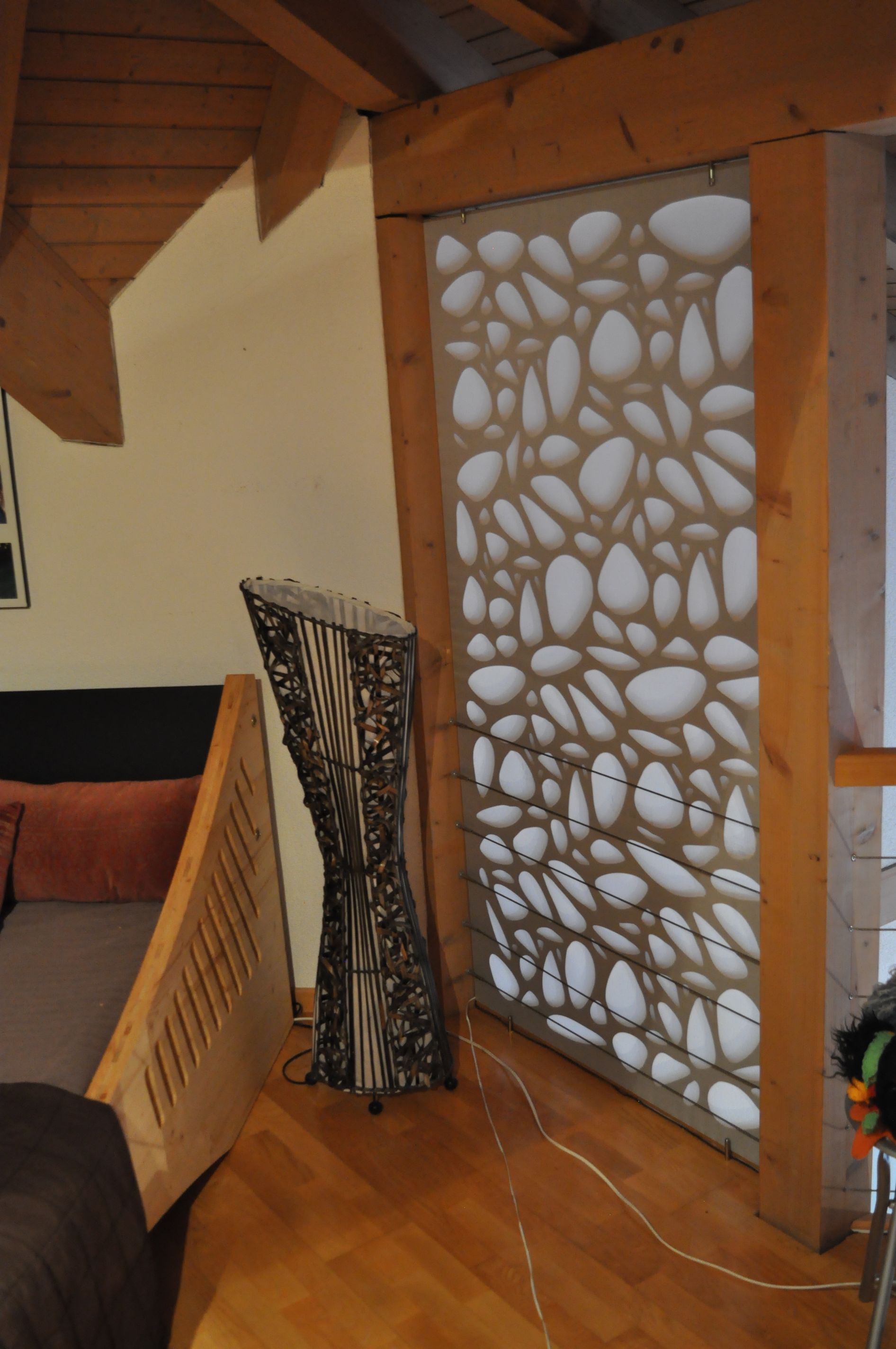 A living room with a wooden staircase and a stone wall