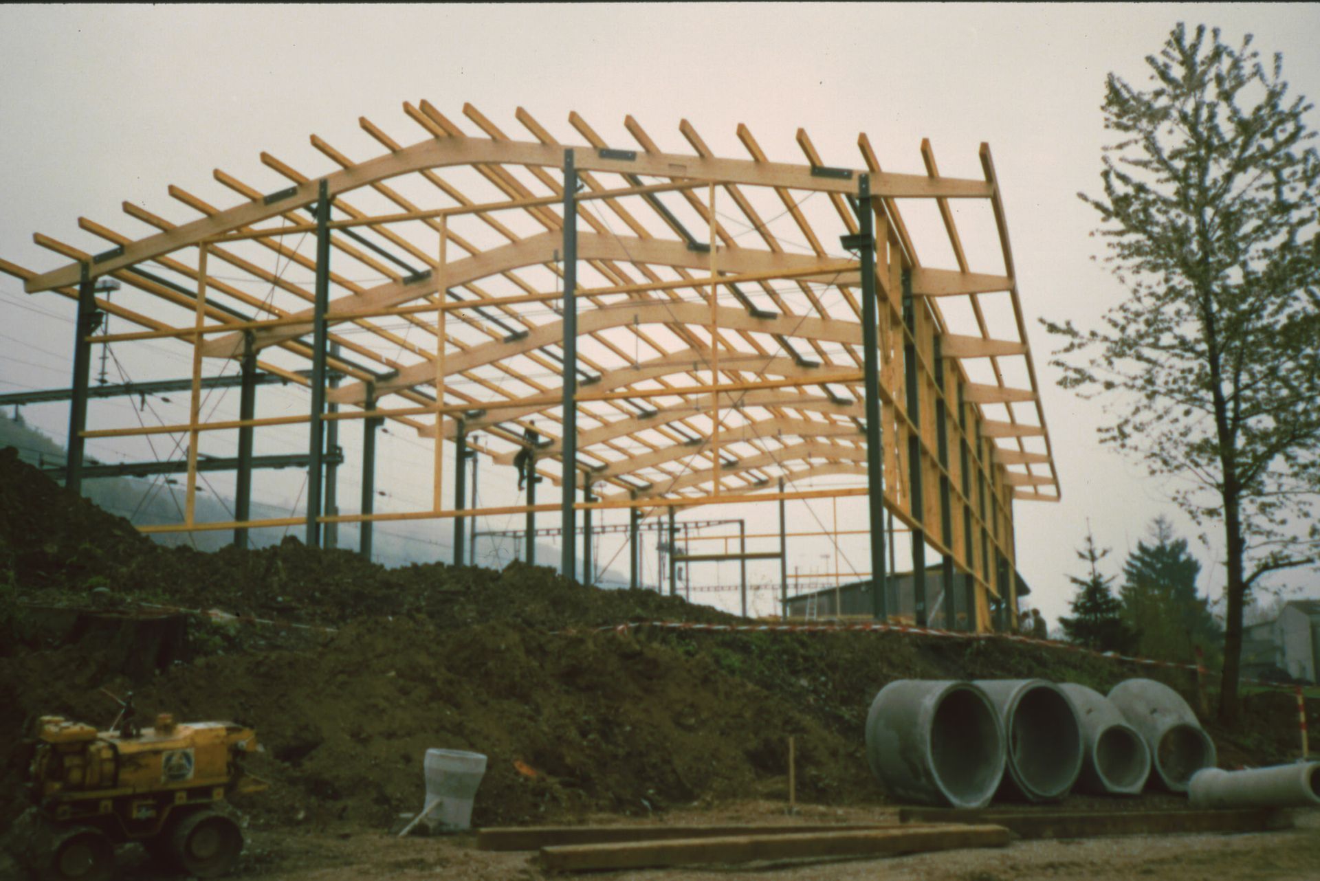 A building under construction with pipes in front of it