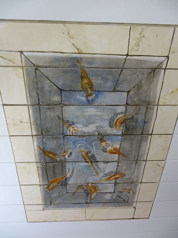 Ein Gemälde von Fischen an der Decke eines Zimmers