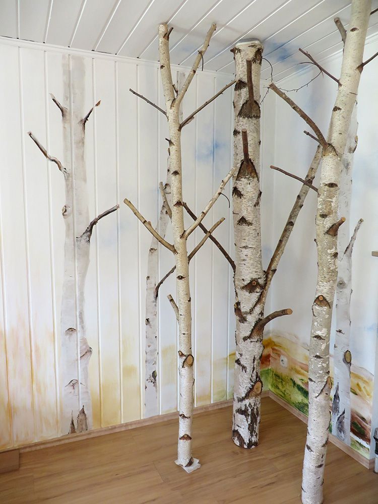 Ein Zimmer mit einem Gemälde von Birken an der Wand