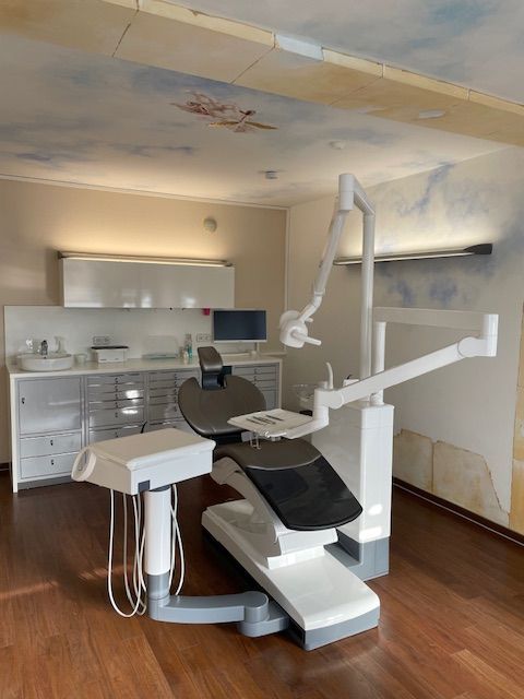 Ein Zahnarzt untersucht die Zähne eines Patienten mit einem Spiegel.