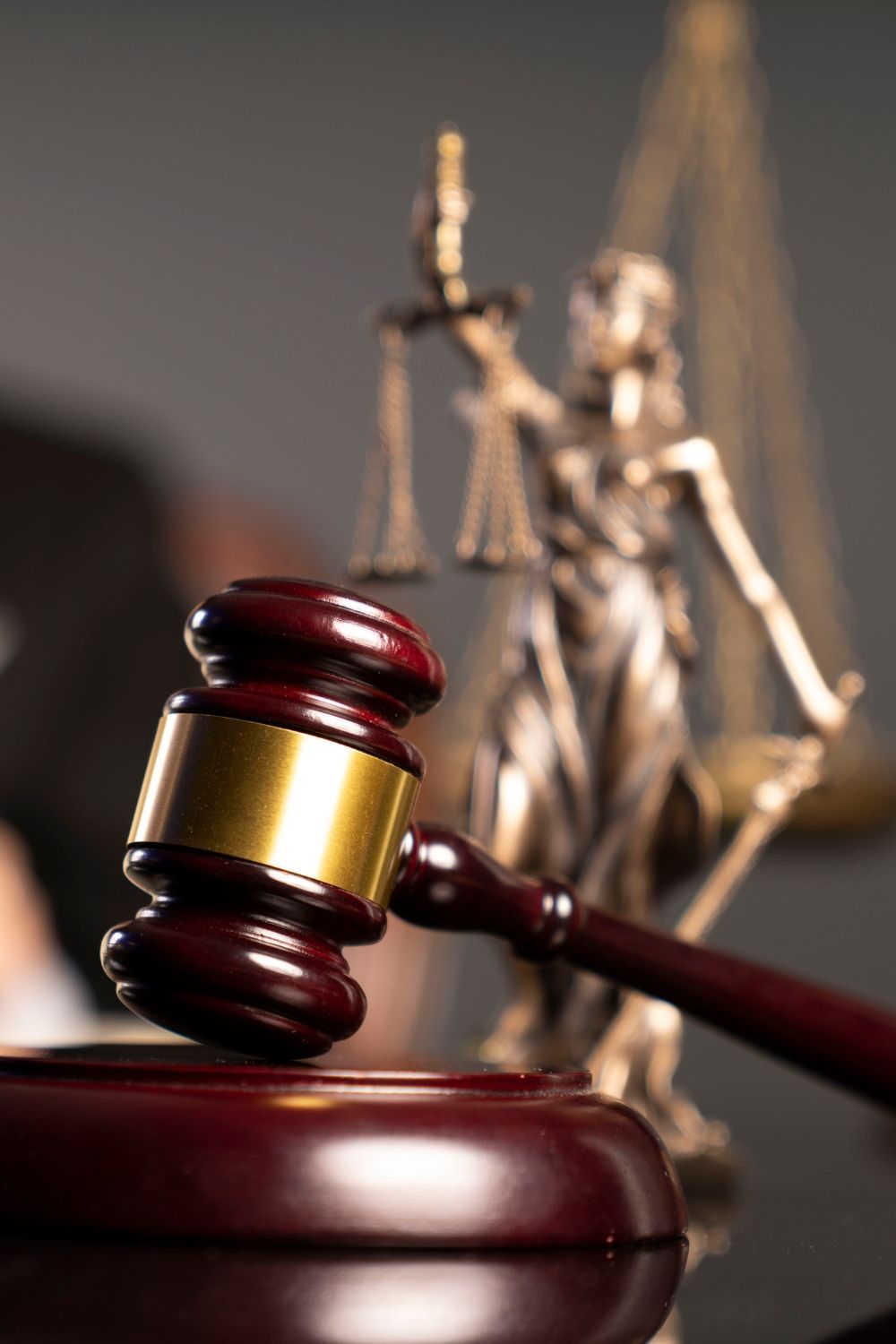 Una estatua de la justicia está detrás de un mazo de madera.