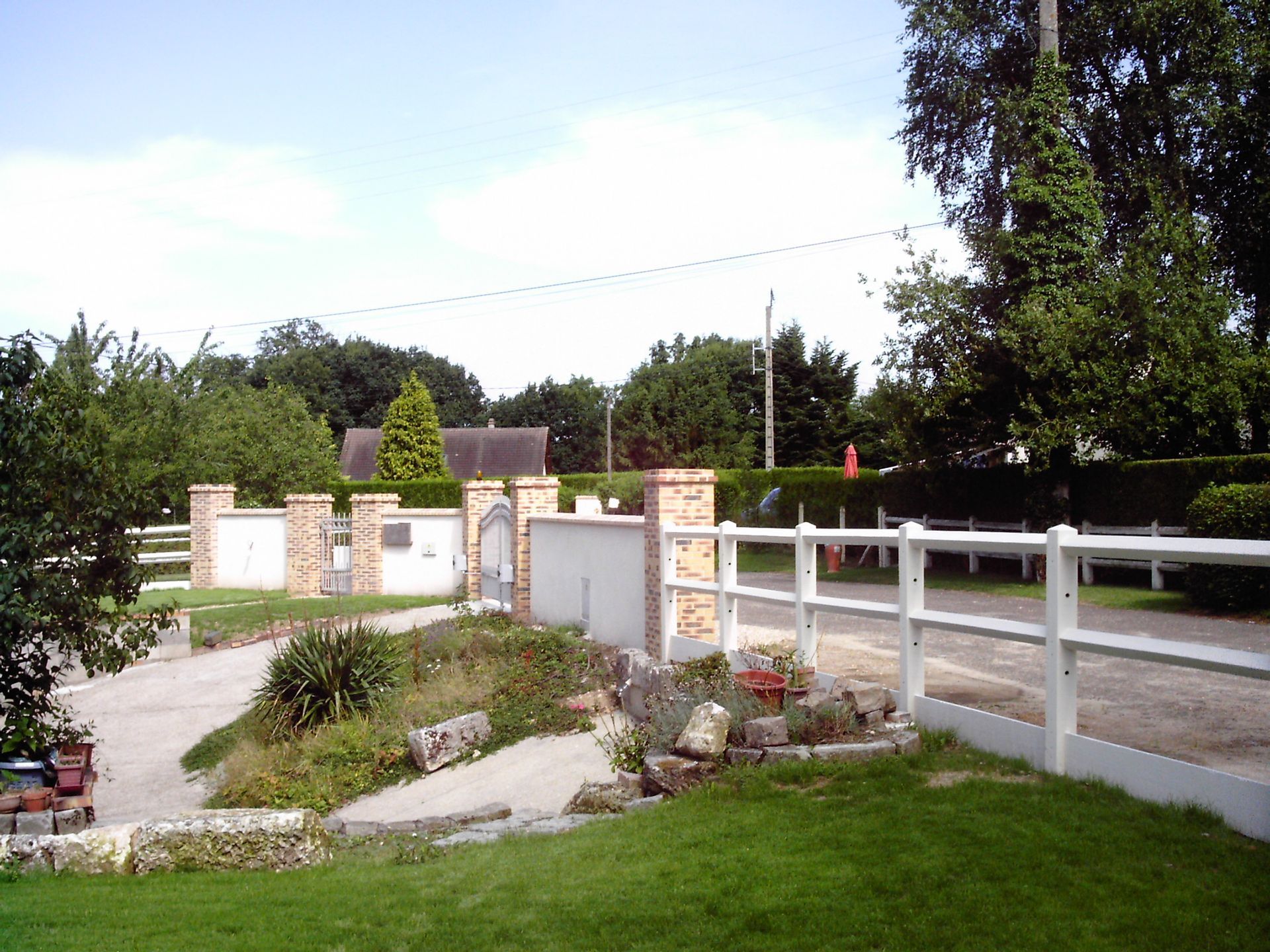 Un jardin entretenu près d'un portail et d'une clôture normande