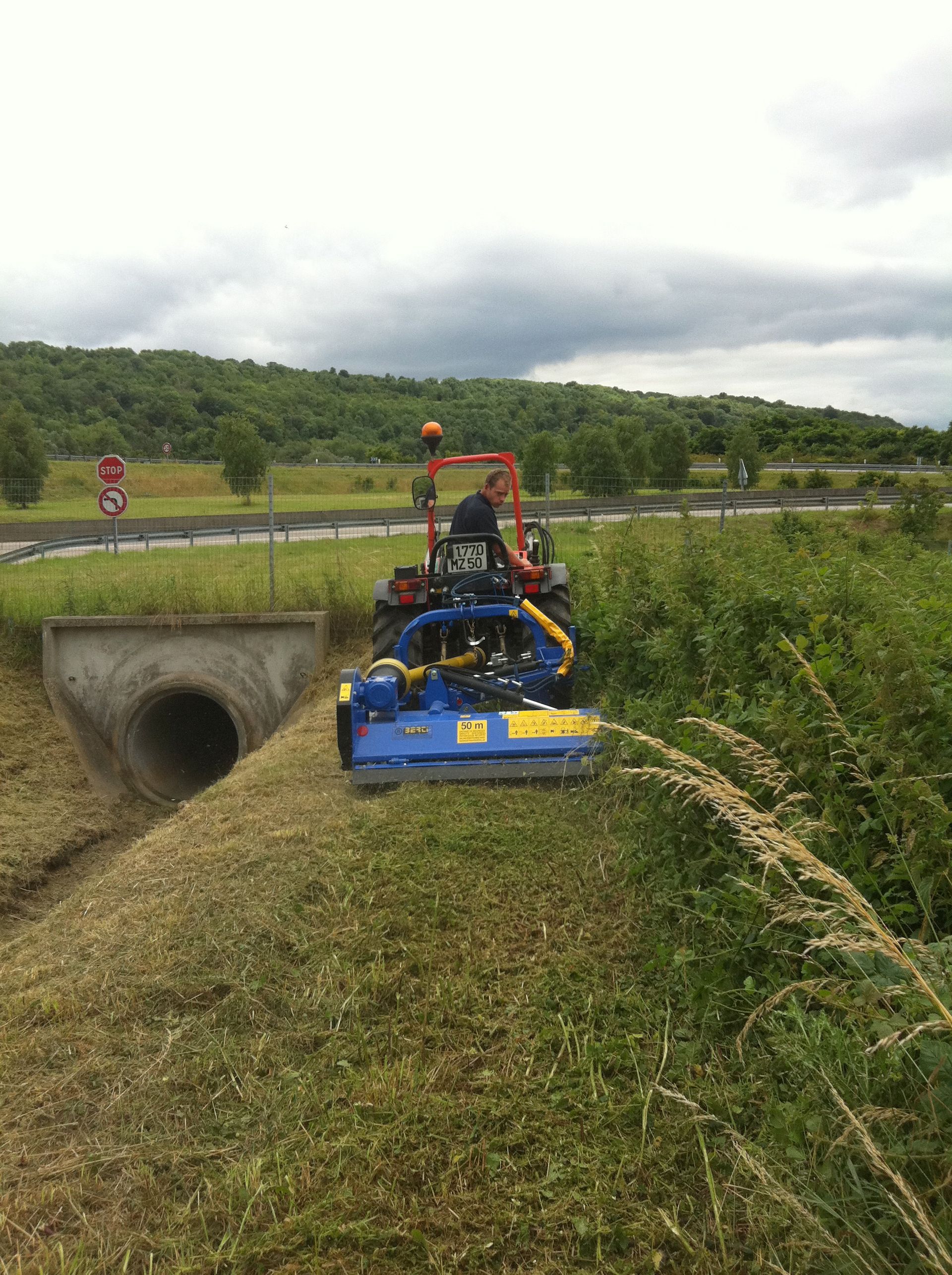 Un ouvrier utilise une machine pour scarifier une pelouse