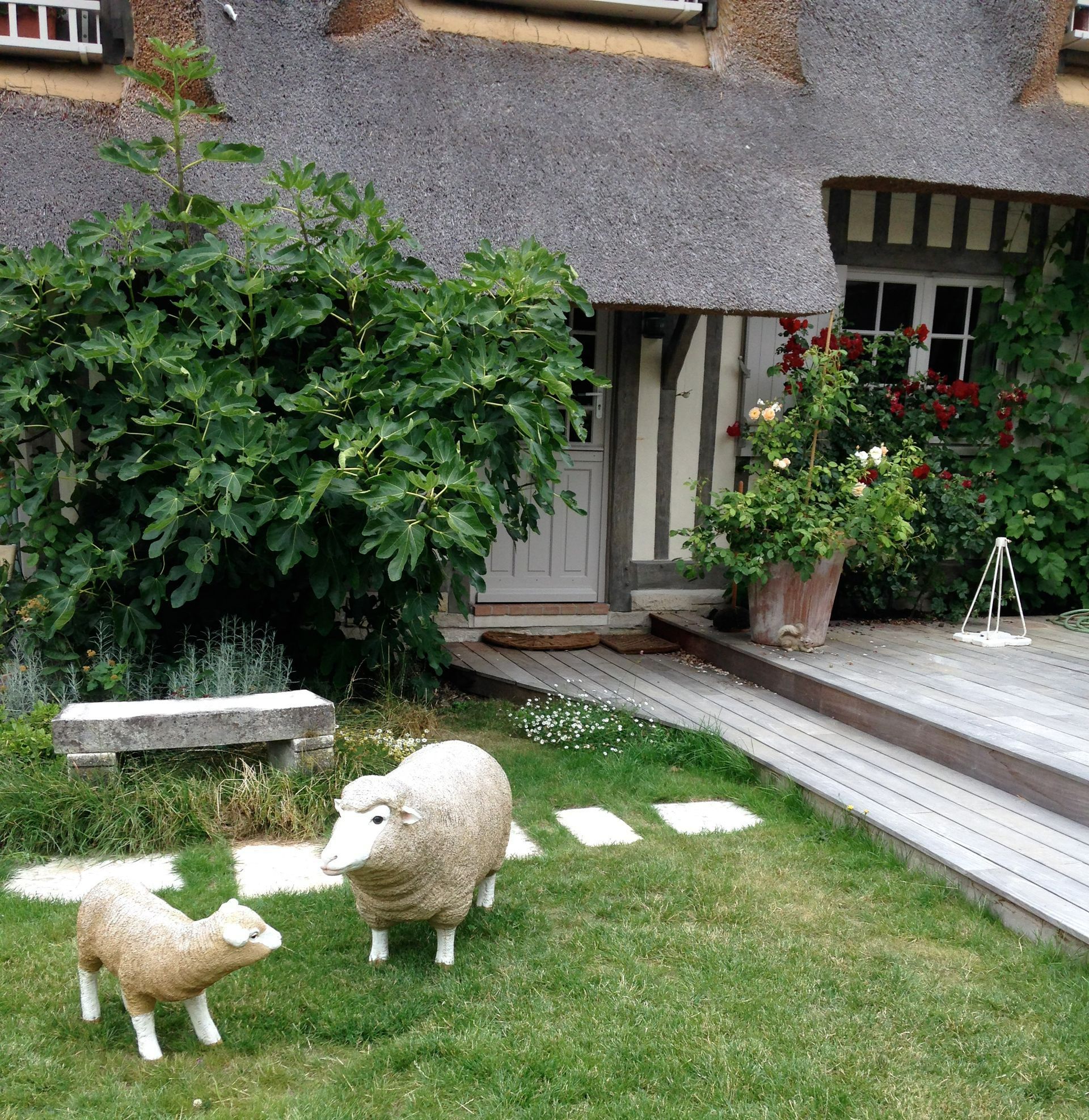 Un jardin avec une terrasse et des sculptures en forme de mouton