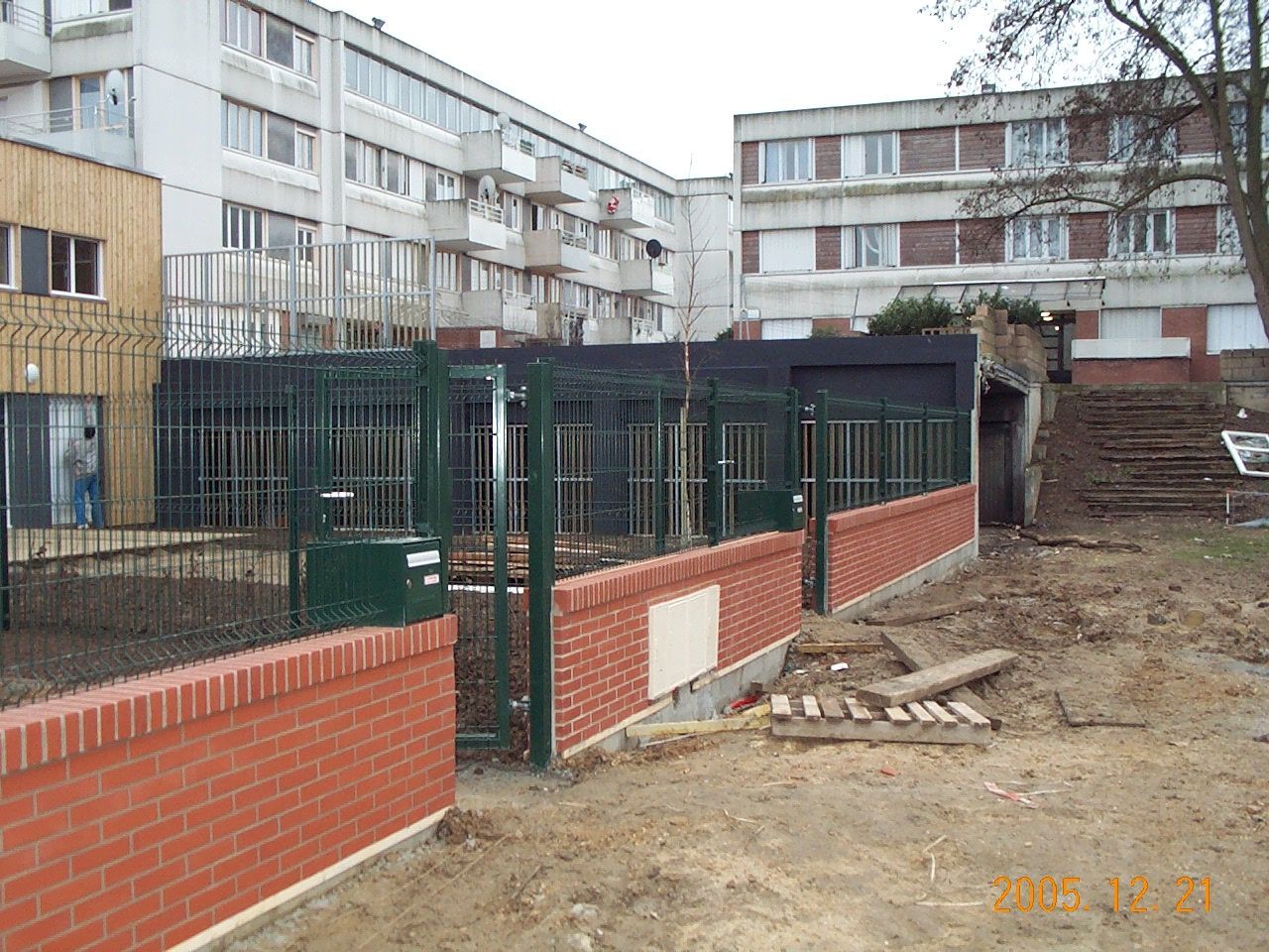 Clôture verte en métal sur un mur avec de fausses briques