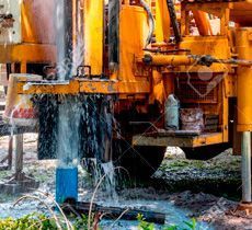Un camión amarillo está perforando un agujero en el suelo.